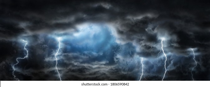 Sun rays in the gap between the clouds and sparkling lightning in the dark sky.  Concept on the theme of weather, natural disasters, storm, typhoons, tornadoes, thunderstorms, zipper, lightning.