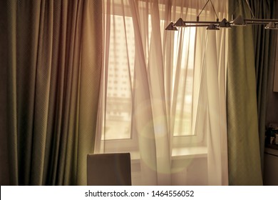 sun rays at home through window shine by early morning, wind is waving transparent curtain, airing room concept