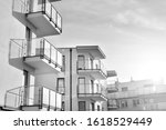 Sun rays light effects on urban buildings. Fragment of modern residential apartment with flat buildings exterior. Detail of new luxury house and home complex. Black and white.