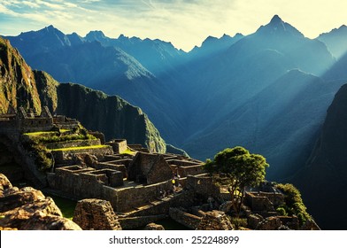 Rayos de luz brillan en las ruinas de Machu Picchu, Perú. Machu Picchu al amanecer cuando la luz del sol hace todo cálido de oro. Valle Sagrado.