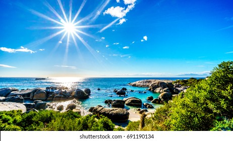 Sun rays over the large granite boulders at Boulders Beach, a popular nature reserve and home to a colony of African Penguins, in the village of Simons Town in the Cape Peninsula of South Africa