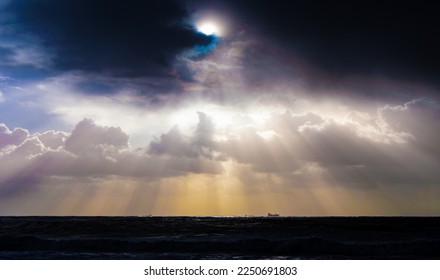 Sun rays peeking through clouds into the water
