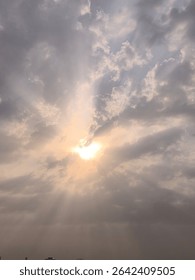 Sun Rays Piercing Through Clouds: A Serene Dawn