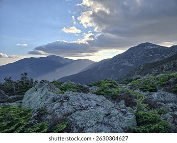 Sun rays shining into the valleys of the Presidential mountain range in New Hampshire. Mount Washington, Mount Jefferson, Mount Addams, and Mount Madison.