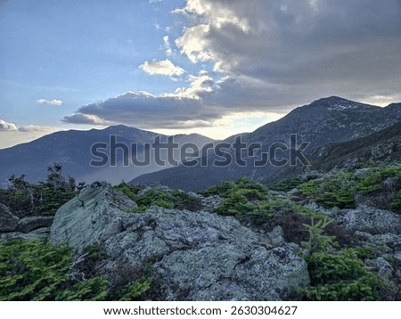 Sun rays shining into the valleys of the Presidential mountain range in New Hampshire. Mount Washington, Mount Jefferson, Mount Addams, and Mount Madison.