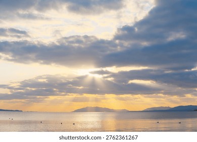 Sun Rays Shining Through the Calm Sea and Sky