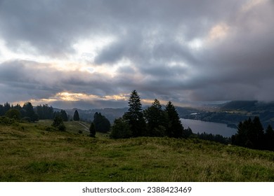 sun rays shining through clouds after sunrise at Alpsee in german alps