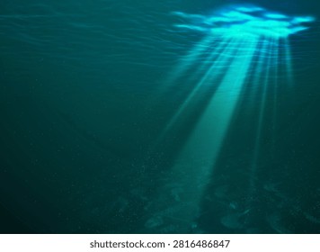 Sun rays shining through ocean surface, underwater view with sandy bottom