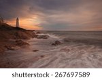 Sun rays shining through stormy clouds on a lighthouse