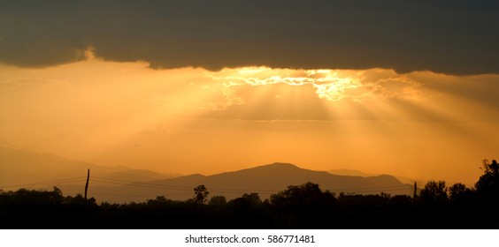 sun rays through the clouds over a mountain,panorama view 