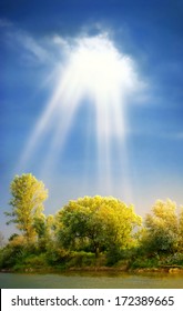 Sun Rays Through Clouds Shine Meadow With  Trees Stock Photo