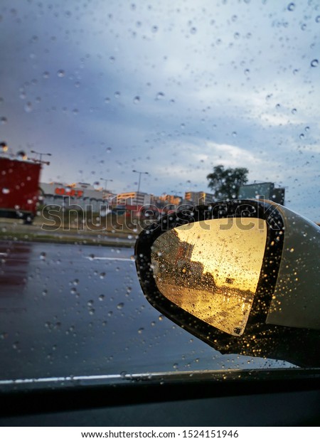 sun reflection in car\
mirror rain
