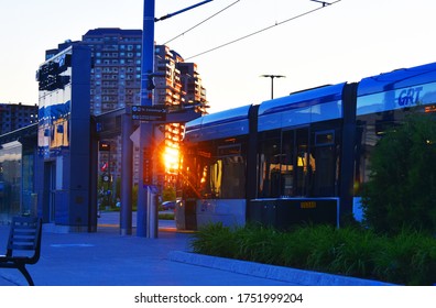 Sun Reflection On A Building With Sun Rays Coming Front Of A Light Rail Train, LRT, From Grand River Transit, GRT, Uptown Waterloo, Ontario, Canada, June, 6, 2020. 