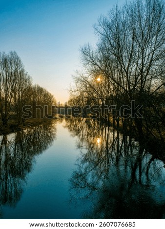 the sun reflection in the quieter river eure ealy in the morning