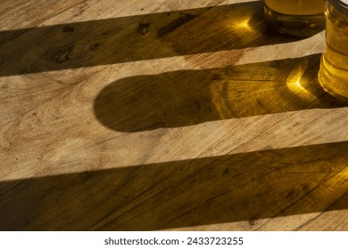 sun reflections of olive oil bottles on a wooden table - Powered by Shutterstock