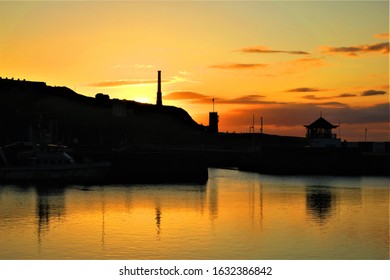 Sun  reflects on the water in Whitehaven Harbour in Cumbria at sunset