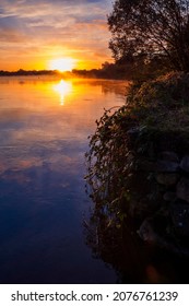 Sun Rise Over River Corrib, Galway City, Ireland. Rich Warm And Cool Colors. Sky And Sun Reflection In Water Surface. Amazing Nature Scene Landscape. Calm And Peaceful Mood.