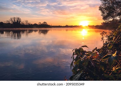 Sun Rise Over River Corrib, Galway City, Ireland. Rich Warm And Cool Colors. Sky And Sun Reflection In Water Surface. Amazing Nature Scene Landscape. Calm And Peaceful Mood.