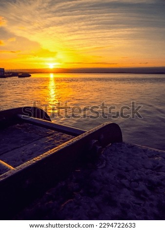 Sun rise scene over the ocean Pier with metal ladder in foreground. Warm saturated color. Galway bay, Ireland. Calm nature scene.