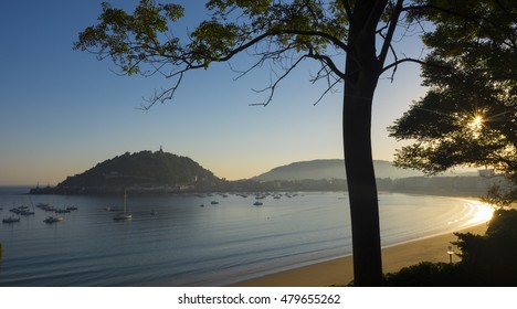 The sun rises in the bay and Shell Beach, city of Donostia