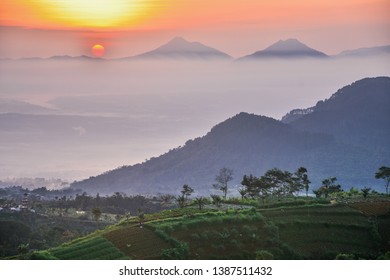 the sun rises between two mountains and covered in white mist