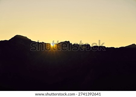 The sun rises from the mountaintop