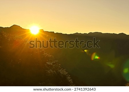 The sun rises from the mountaintop