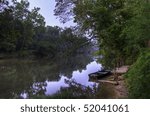 The sun rises on a dock and small fishing boat on the Meramec River in Central Missouri.