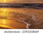 As sun rises over waves of ocean in early hours morning