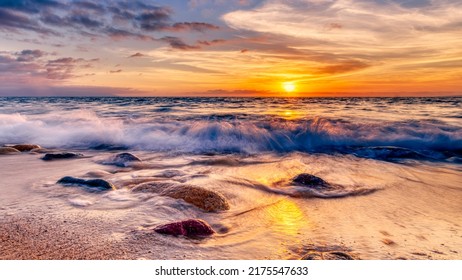 The Sun Rises As A Wave Splashes On A Colorful Tropical Beach High Resolution