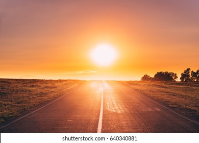 Sun Rising Over Asphalt Country Open Road In Sunny Morning Or Evening. Open Road In Europe In Summer Or Autumn Season At Sunny Sunset Or Sunrise Time