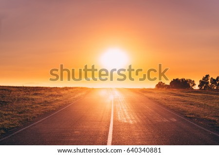 Sun Rising Over Asphalt Country Open Road In Sunny Morning Or Evening. Open Road In Europe In Summer Or Autumn Season At Sunny Sunset Or Sunrise Time