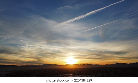 Sun Rising Over Mountains Warming City Below