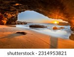 Sun rising over Pacific ocean horizon from inside sea cave in Caves beach of Australia.