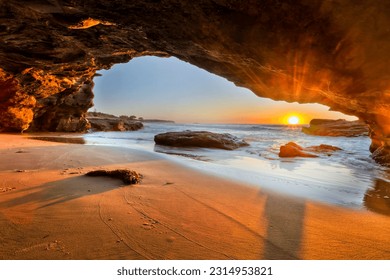 Sun rising over Pacific ocean horizon from inside sea cave in Caves beach of Australia. - Powered by Shutterstock