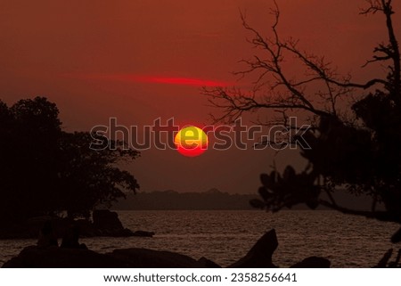 sun set over horizon made sihouette of an island and tree