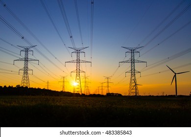 The Sun Sets Behind The Lines Of Hydro Towers With One Lonely Windmill On The Side, In The Southern Bruce Peninsula.