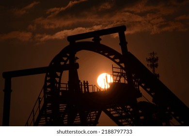 Sun Sets Behind Rollercoaster Silhouette 