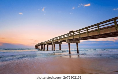 The sun sets behind the St. Johns County Ocean Pier in St. Augustine, Florida.