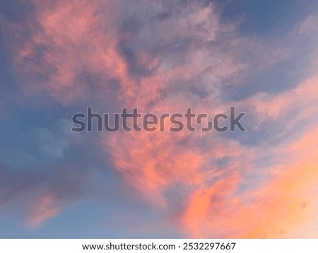 As the sun sets, dark clouds gather ominously, swirling in shades of orange and purple. The vibrant sky hints at an approaching storm, creating a breathtaking yet unsettling scene.