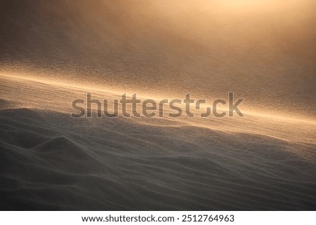 The sun sets as high winds blow sand over the dunes at White Sands National Park near Alamogordo, New Mexico.