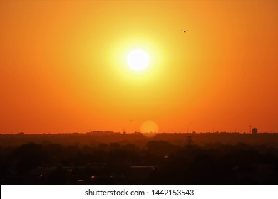 The Sun Sets On A Blistering Hot Summer Day Over The Powerlines And Tress Of Lincoln, Nebraska. 