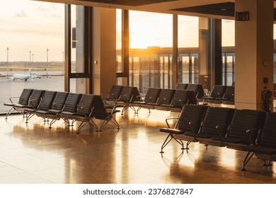 Sun sets outside of empty modern airport departures lounge