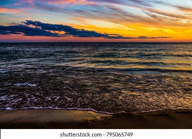 The Sun Sets Over A Calm And Peaceful Lake Michigan At Grand Haven, Michigan