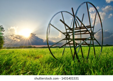 The Sun Sets Over A Grass Field With Machinery In Frisco, TX