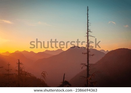 The sun sets over the layered peaks of the coastal mountains on Vancouver Island between Port Alberni and Tofino, BC.