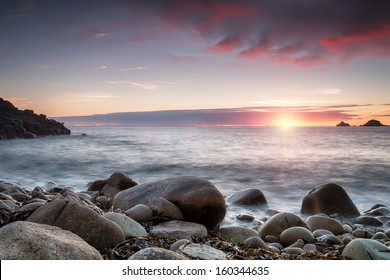 The sun sets over Porth Nanven Cove near Penzance in Cornwall, also known as Cot Valley - Powered by Shutterstock