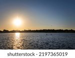 The sun sets, while people enjoy the remaining day, at the harbor in Manitowoc, Wisconsin.