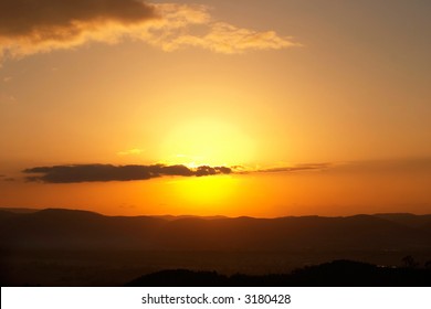 Sun setting behind a cloud