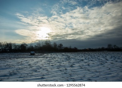 The sun setting behind the cloud and snow in the field - winter view